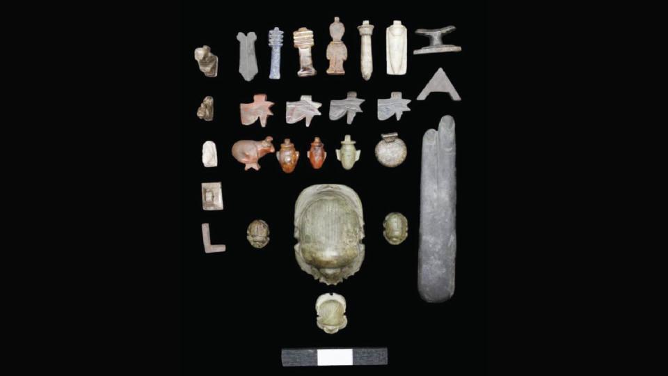 An array of stone artifacts depicting scarabs, cows, and abstract figures