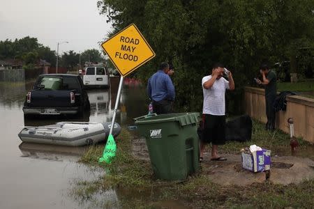 Residents make phone calls from high ground after heavy downpours unleashed flash floods in Mercedes, Texas, U.S., June 20, 2018. REUTERS/Adrees Latif