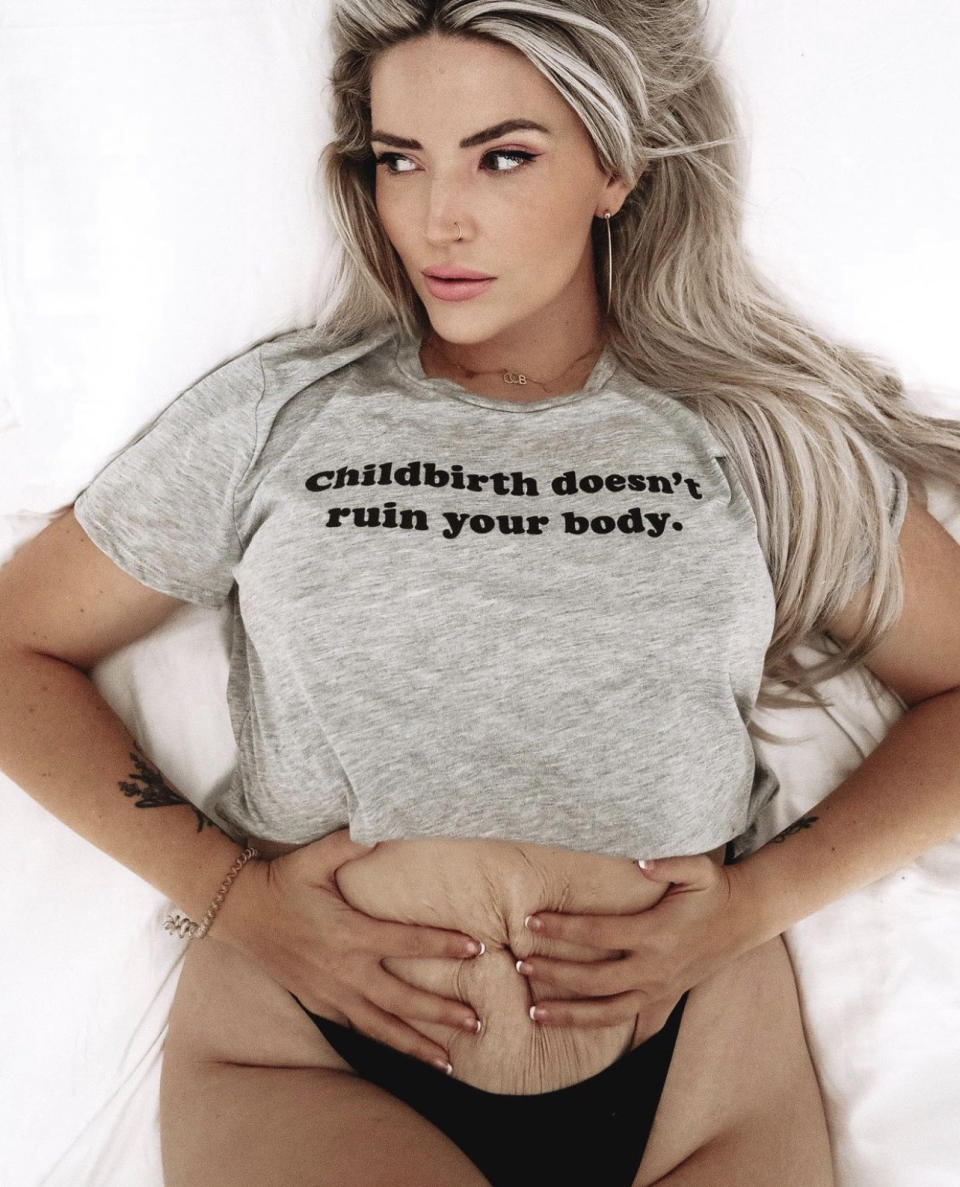 A woman wearing a shirt that says, "childbirth doesn't ruin your body"