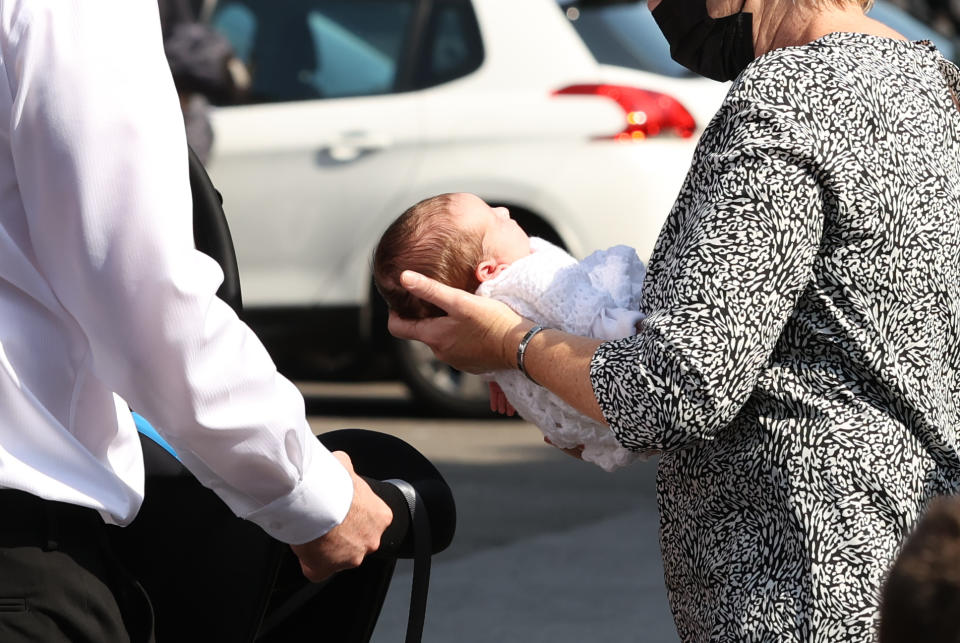 Husband Josh with his newborn daughter Eviegrace, being carried by a relative (name not known) after the coffin of Samantha Willis (nee Curran) from Strathfoyle is taken from St Columb's Church, Londonderry, following her funeral. The mother-of-four died with Covid-19 shortly after giving birth on Friday. Picture date: Monday August 23, 2021.