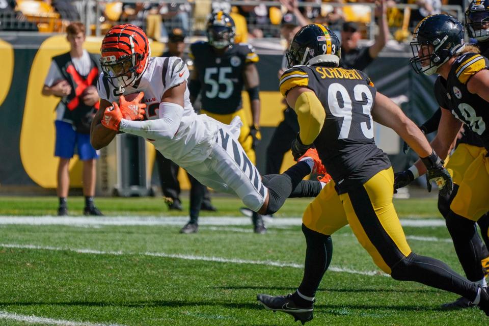 Cincinnati Bengals wide receiver Tyler Boyd (83) dives past Pittsburgh Steelers inside linebacker Joe Schobert (93) for a touchdown during the first half an NFL football game, Sunday, Sept. 26, 2021, in Pittsburgh. (AP Photo/Gene J. Puskar)