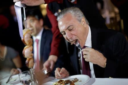 El presidente de Brasil, Michel Temer, en un asado con embajadores de países importadores de carne en Brasilia 19, 2017 El impacto por el escándalo de corrupción en la industria cárnica brasileña se extendió el lunes, después de que China y Corea del Sur suspendieron algunas importaciones, la Unión Europea anunció que estudiaba acciones y los títulos de los frigoríficos BRF y JBS cayeron con fuerza. . REUTERS/Ueslei Marcelino