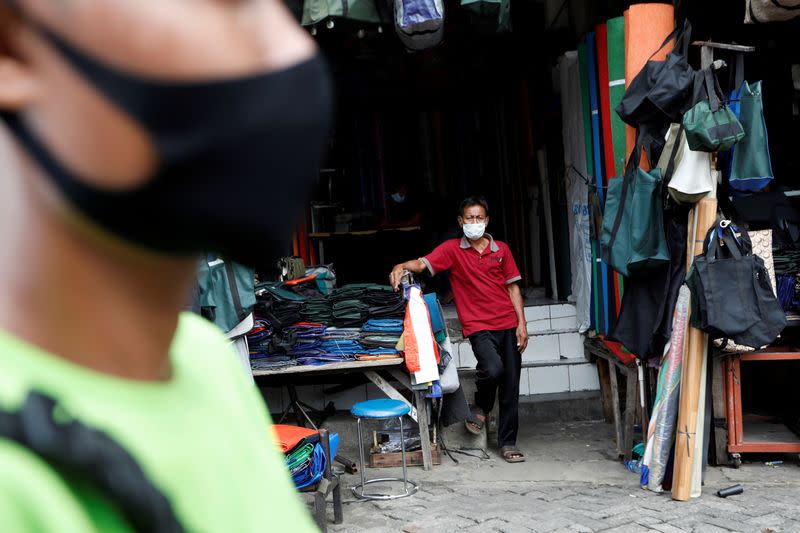 A shopkeeper stands at a stall as he waits for customers at Tanah Abang textile market, as the outbreak of the coronavirus disease (COVID-19) continues in Jakarta