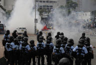 Riot police fire tear gas to protesters outside the Legislative Council in Hong Kong, Wednesday, June 12, 2019. Hong Kong police have used tear gas and high-pressure hoses against thousands of protesters opposing a highly controversial extradition bill outside government headquarters. (AP Photo/Vincent Yu)