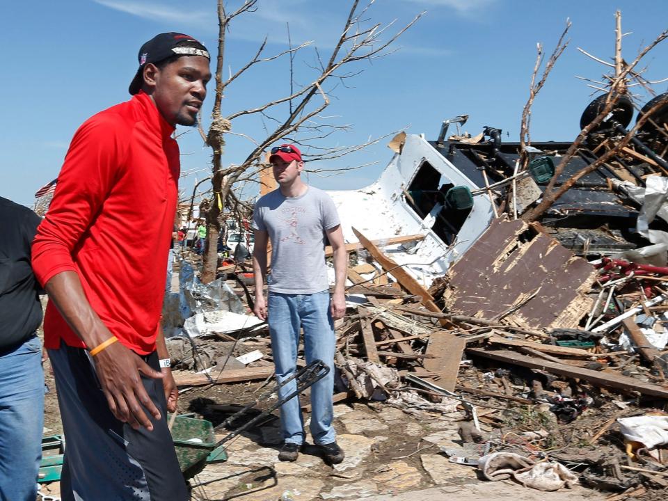 Kevin Durant stands beside wreckage from a tornado in Oklahoma in 2013.