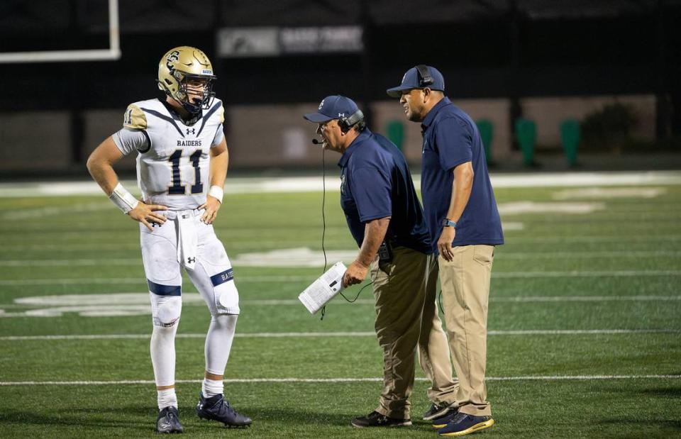 Central Catholic coaches Roger Canepa, middle, and Tim Garcia talk with quarterback Tyler Wentworth during the game with St. Mary’s in Stockton, Calif., Friday, August 25, 2023. St. Mary’s won the game 42-33.