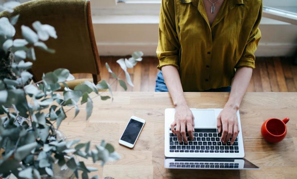 A woman uses a laptop at a table