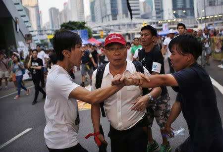 Pro-democracy protesters argue with a man as he walks away from an area blocked by protesters outside the government headquarters office in Hong Kong, October 9, 2014. REUTERS/Carlos Barria