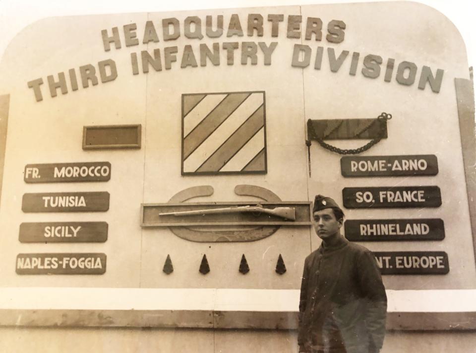 Larry Simon poses at a sign outside the 3rd Infantry Division’s headquarters in Kassel, Germany, that highlighted the various campaigns in which the division fought during World War II. 