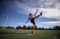 Simon Fraser University football team kicker Kristie Elliott, kicks a ball while posing for a photograph before practice in Burnaby, B.C., Tuesday, Sept. 21, 2021. The 21-year-old Elliott booted a pair of successful conversions against Oregon’s Linfield University on Sept. 11, becoming the first Canadian woman to play in — and score in — an NCAA football game. (Darryl Dyck/The Canadian Press via AP)