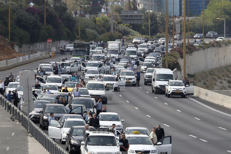 Drivers stop and stand in silence on a highway in Tel Aviv.