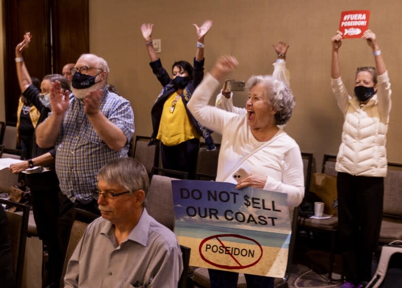 Costa Mesa, CA - May 12: Debbie Andrews, center, of Huntington Beach, celebrates with others as the California Coastal Commission rejects a plan for Poseidon Water to build a desalination plan in Huntington Beach at the California Coastal Commission hearing Thursday, May 12, 2022 at the Hilton Orange County Costa Mesa. (Allen J. Schaben / Los Angeles Times)