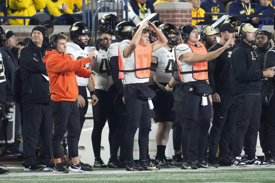 Purdue players signal offensive plays to the field from the sidelines against Michigan in the first half of an NCAA college football game in Ann Arbor, Mich., Saturday, Nov. 4, 2023. (AP Photo/Paul Sancya)