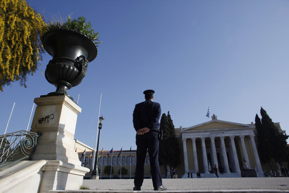 A police officer stands in front of Zappeion hall during a Eurogroup meeting, in Athens on Tuesday, April 1, 2014. Finance ministers from the eurozone and the wider European Union are gathering in Athens amid tight security, with Greece hoping for a gesture of support for the release of long-delayed funds from the country's multi-billion-euro bailout. (AP Photo/Kostas Tsironis)
