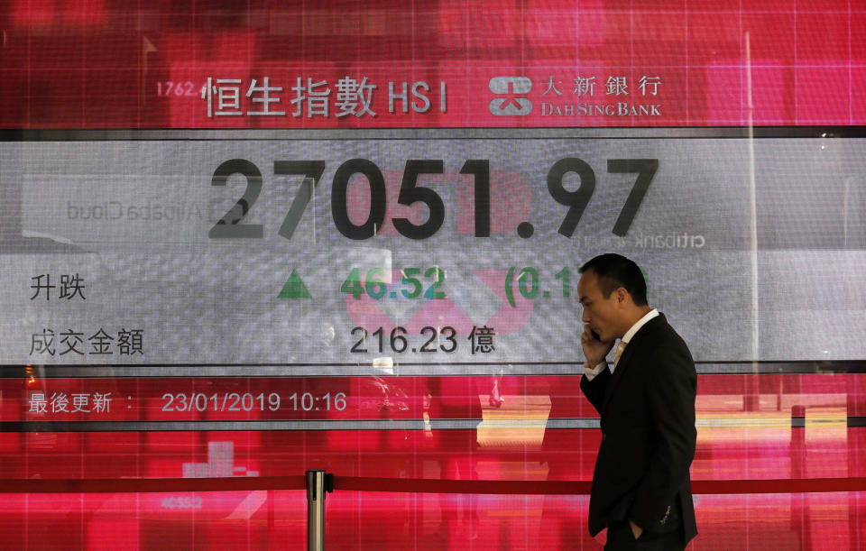 A man walks past an electronic board showing Hong Kong share index outside a local bank in Hong Kong, Wednesday, Jan 23, 2019. Asian markets edged higher on Wednesday but trading was subdued with poor Japanese trade data and a possible bump in U.S-China talks. (AP Photo/Vincent Yu)