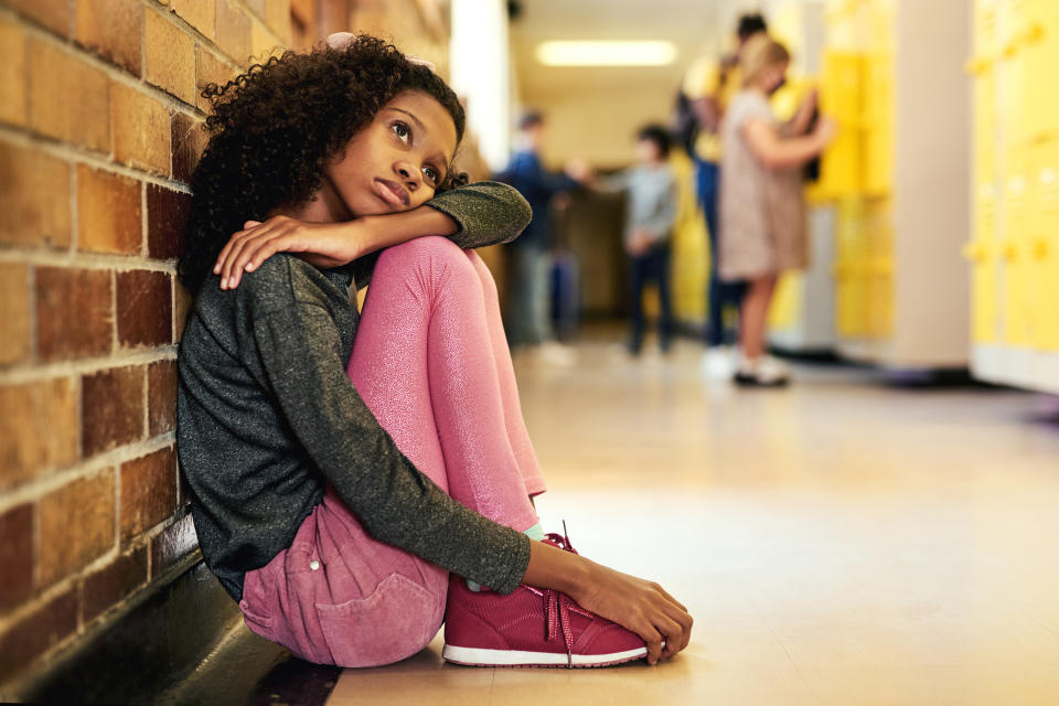 a teenager sitting on the floor