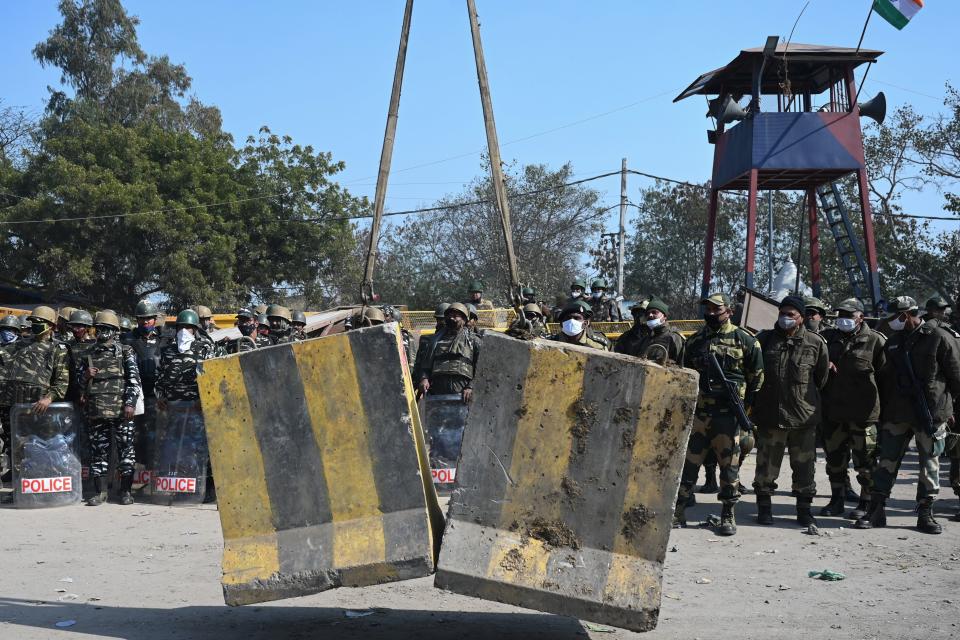 Security forces watch as police (not pictured) set up road blocks at the Delhi-Haryana state border in Singhu on January 27, 2021, as farmers continue to demonstrate against the central government's recent agricultural reforms. (Photo by Money SHARMA / AFP) / The erroneous mention[s] appearing in the metadata of this photo by Money SHARMA has been modified in AFP systems in the following manner: [at the Delhi-Haryana state border in Singhu] instead of [at Singhu border in New Delhi]. Please immediately remove the erroneous mention[s] from all your online services and delete it (them) from your servers. If you have been authorized by AFP to distribute it (them) to third parties, please ensure that the same actions are carried out by them. Failure to promptly comply with these instructions will entail liability on your part for any continued or post notification usage. Therefore we thank you very much for all your attention and prompt action. We are sorry for the inconvenience this notification may cause and remain at your disposal for any further information you may require. (Photo by MONEY SHARMA/AFP via Getty Images)