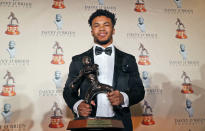 Heisman Trophy winner quarterback Kyler Murray posses with the Davey O'Brien football award he received in Fort Worth, Texas, Monday, Feb. 18, 2019. Murray accepted the Davey O'Brien award in his first public appearance since the Heisman Trophy winner announced his plan to pursue an NFL career rather than report to spring training as a first-round pick of the Oakland A's. (AP Photo/LM Otero)