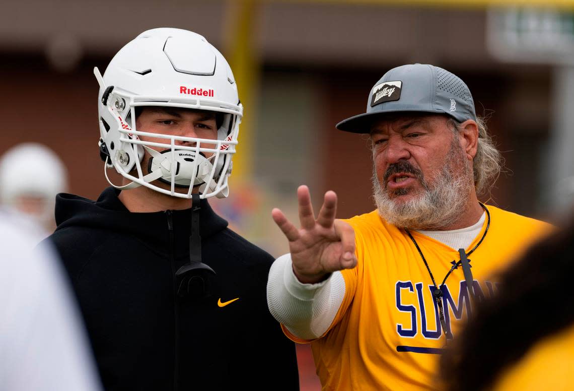 Sumner football coach Keith Ross coaches linebacker Austin Gilvar during a football practice at Sumner High School, on Thursday, Aug. 22, 2024, in Sumner, Wash.