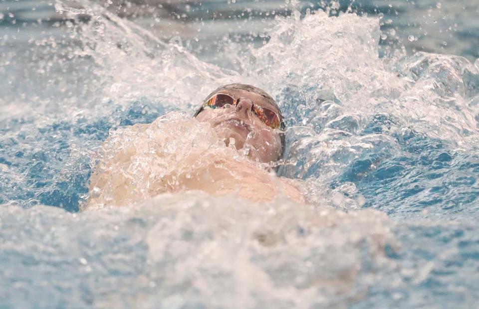 Highland's Henry Wilkes swims to a first place finish in the 100 yard backstroke event during the Suburban American League Championships swim meet at the Ocasek Natatorium on the University of Akron campus.