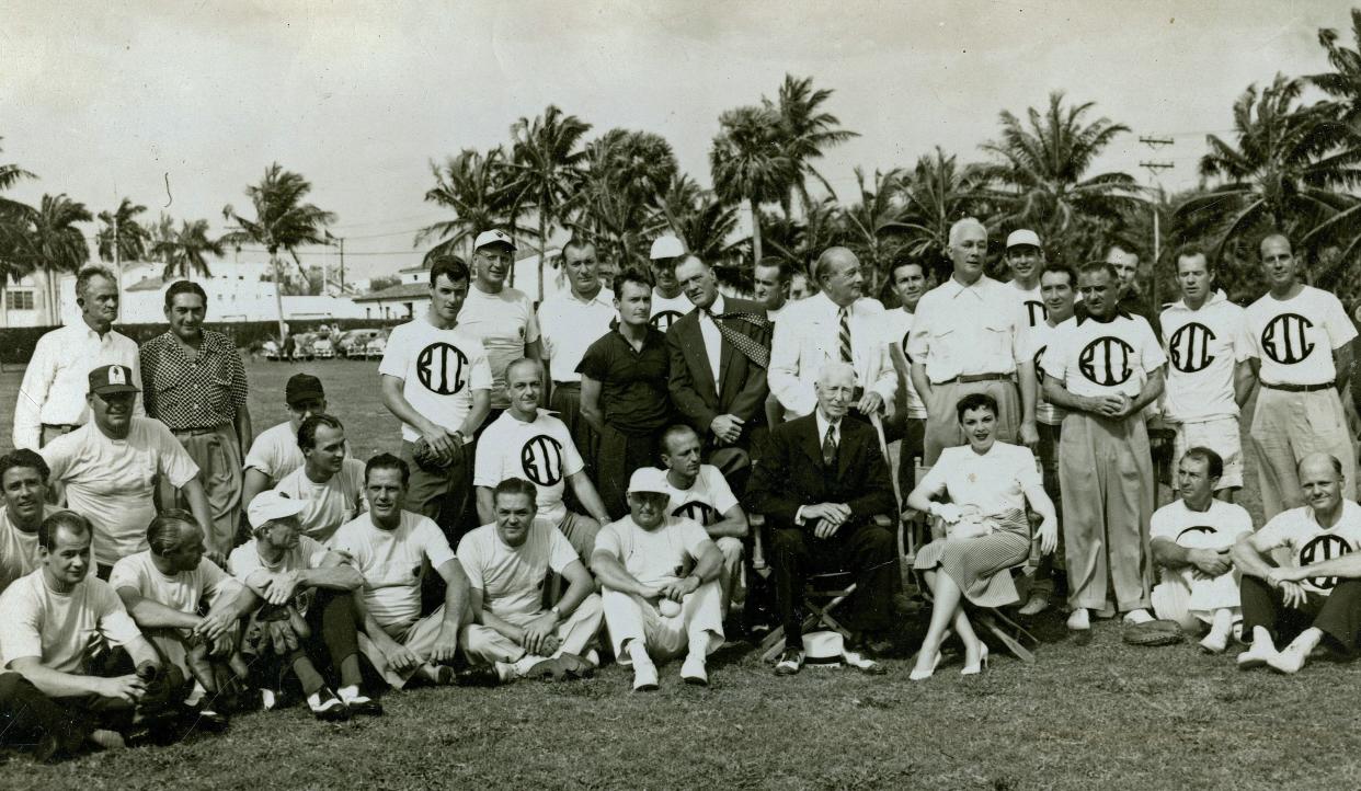 The 1952 society baseball teams representing the Bath & Tennis and The Everglades clubs. Judy Garland, who threw out the game's first ceremonial pitch, is seated at center right. Seated to her left is legendary baseball manager Connie Mack. Seated at far left is actor Peter Lawford.