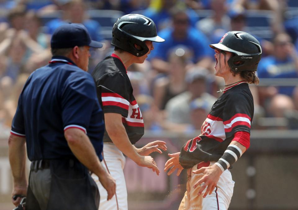 Hiland's Alec Weaver, right, celebrates after scoring a run against Russia during the fifth inning of the OHSAA Division IV state championship baseball game at Canal Park, Saturday, June 10, 2023, in Akron, Ohio.