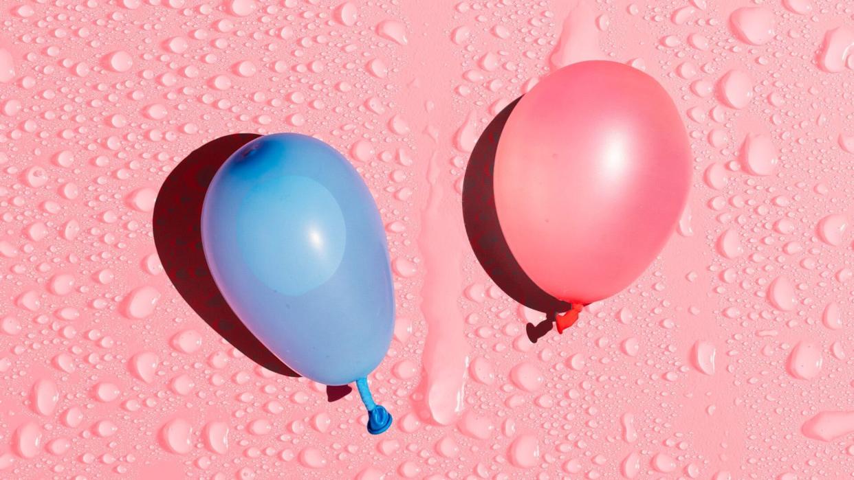 Blue and pink water balloons on a pink wet background.