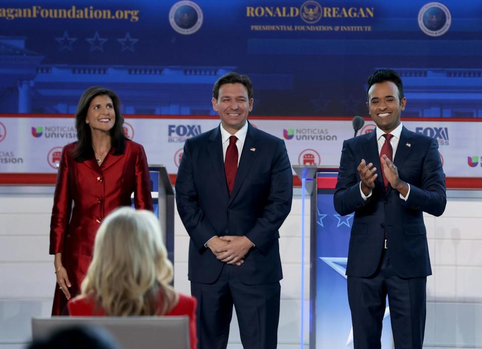 Three people standing on a stage.