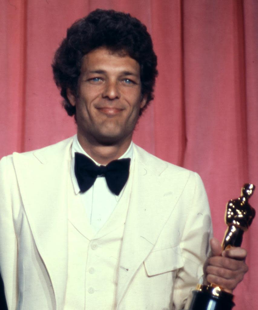 FILE - In this April 8, 1975 file photo, movie producer Bert Schneider holds the Oscar he received with co-producer Peter Davis for Best Documentary feature, "Hearts and Minds," at the 47th annual Academy Awards in Los Angeles, Calif. Schneider used the opportunity to read a telegram from the North Vietnamese ambassador at the Paris peace talks. (AP Photo/File)