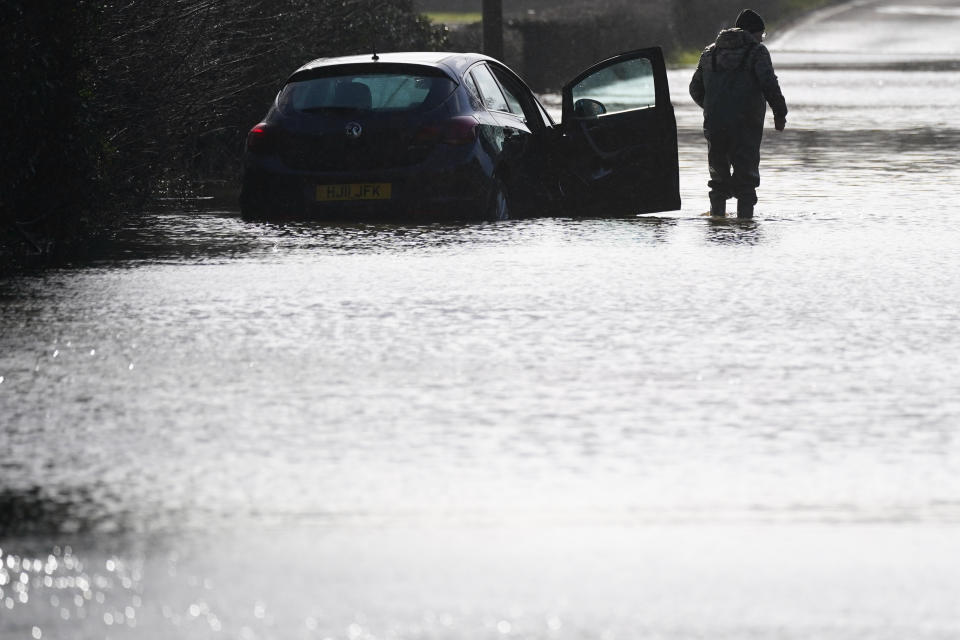 A man alongside a stranded car in flood water on the A6 near Milford, Derbyshire, as Britons have been warned to brace for strengthening winds and lashing rain as Storm Franklin moved in overnight, just days after Storm Eunice destroyed buildings and left 1.4 million homes without power. Picture date: Monday February 21, 2022.