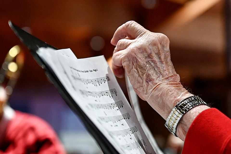 Henry Nelson, 100, organizes his sheet music before starting another number while playing his tuba in the Asbury Brass Quintet during a performance on Wednesday, Dec. 7, 2022, at Ascension Lutheran Church in East Lansing.