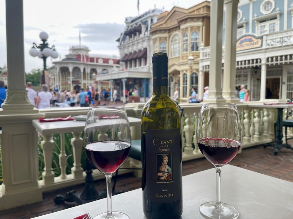 bottle of red wine with two glasses at tony's restaurant on main street in magic kingdom