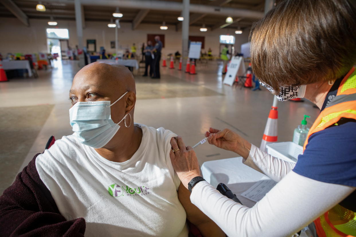 Nurse Megan Williams administers a dose of the Pfizer vaccine against the coronavirus disease (COVID-19) to Lestine Washington, 59, at Richmond raceway in Richmond, Virginia, U.S., March 4, 2021. REUTERS/Julia Rendleman