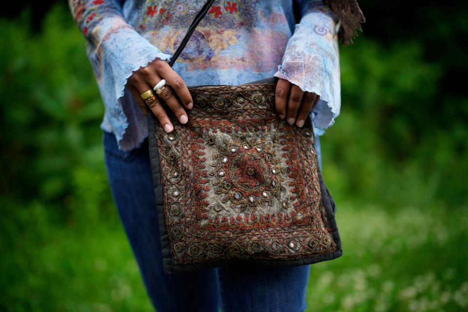 Yasmeen Bekhit, a 22-year-old graduate student, holds her Y2K-inspired bag while posing for a photograph near her home in Manheim, Pa., Tuesday, June 27, 2023. If there’s one thing retailers will tell you, it’s that Gen Z hasn’t let up on early 2000s trends that are booming in popularity two decades later. (AP Photo/Matt Slocum)