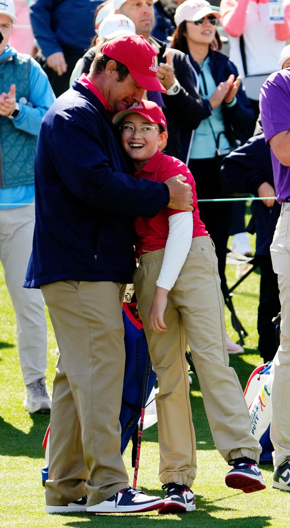 Lily Wachter, from St. Augustine, Fla., gets a congratulatory hug after becoming the overall winner in the girls 10-11 age group during the Drive, Chip & Putt National Finals competition at Augusta National Golf Club.