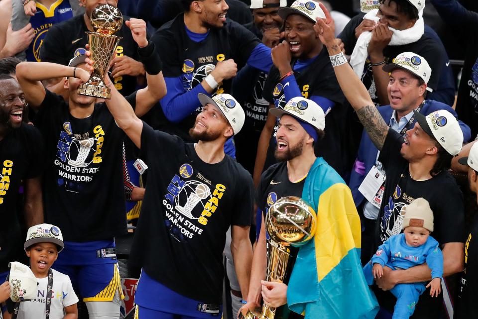 Stephen Curry holds up the Bill Russell Trophy after being selected the Most Valuable Player after the Warriors beat the Celtics in Game 6.