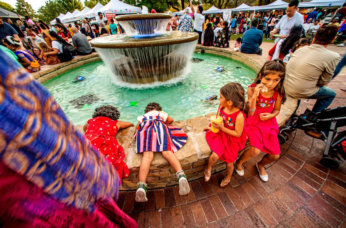 Thousands joined the celebration of Diwali at the Rustin Pavilion in the Southlake Town Square Saturday, Oct. 22, 2022. Nipa Guswarambi, 6, left, joins younger sister, Dhiti, 3, at the fountain, while Priya Abbott, 6 and older sister, Roma, enjoy sweet treats.  