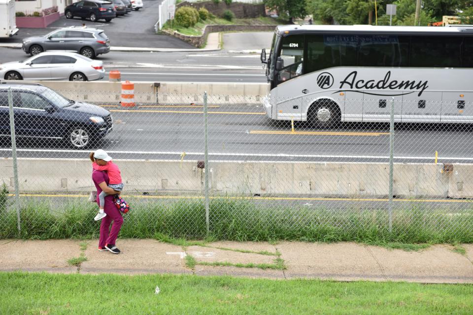 A woman carries her child along a walkway past the construction on the Route 495 bridge to the Lincoln Tunnel, which has closed the left lane in each direction in North Bergen on Monday August 20, 2018. 