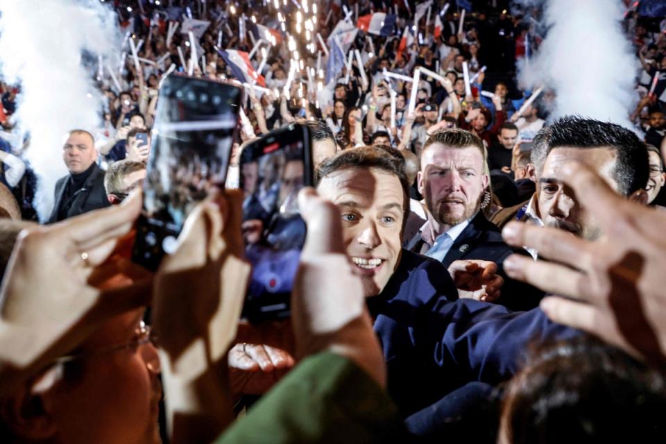 French President Emmanuel Macron greets people as he arrives for his first campaign meeting on the outskirts of Paris (AFP/Getty)