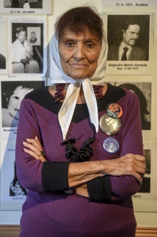 Taty Almeida, a member of the Argentine human rights group Madres de Plaza de Mayo, poses in front of portraits of her son Alejandro Almeida and other victims of forced disappearance, at the organization's building in Buenos Aires