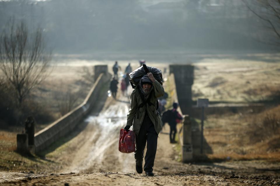 Migrants walk to enter Greece from Turkey by crossing the Maritsa river (Evros river in Greek) near the Pazarkule border gate in Edirne, Turkey, Sunday, March. 1, 2020. The United Nations migration organization said Sunday that at least 13,000 people were massed on Turkey's land border with Greece, after Turkey officially declared its western borders were open to migrants and refugees hoping to head into the European Union. (AP Photo/Emrah Gurel)