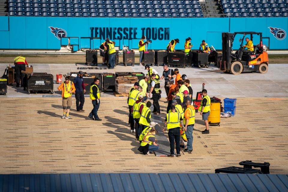 Workers continue building the hockey rink in preparation for the 2022 Navy Federal Credit Union NHL Stadium Series game at Nissan Stadium in Nashville, Tenn., Wednesday, Feb. 16, 2022.