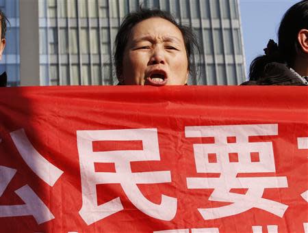 Supporters of Xu Zhiyong, one of China's most prominent rights advocates, shout slogans near a court where Xu's trial is being held, in Beijing January 22, 2014. REUTERS/Kim Kyung-Hoon