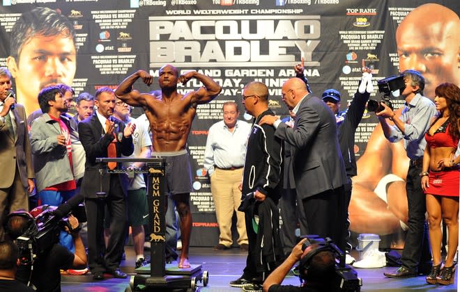 Manny Pacquiao (L) of the Philippines looks on as Timothy Bradley of US stands on a scale during weigh-in at the MGM Grand Arena in Las Vegas, Nevada on June 08, 2012. Pacquiao and Bradley will fight on June 9. AFP PHOTO / JOE KLAMARJOE KLAMAR/AFP/GettyImages