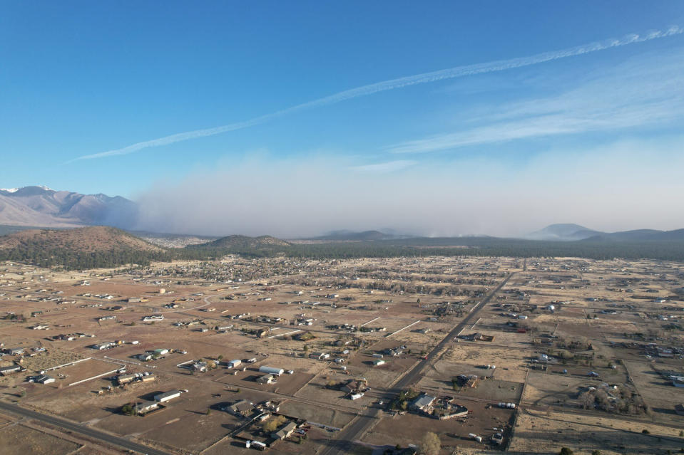 This Twitter photo provided by Zak Pressley shows a wildfire burning in Doney Park in Coconino County, Ariz., on Tuesday, April 19, 2022. An Arizona wildfire doubled in size overnight into Wednesday, a day after heavy winds kicked up a towering wall of flames outside a northern Arizona tourist and college town, ripping through two dozen structures and sending residents of more than 700 homes scrambling to flee. (Zak Pressley via AP)