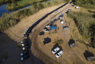 A line of Texas Department of Safety vehicles lines the bank of the Rio Grande near an encampment of migrants, many from Haiti, Wednesday, Sept. 22, 2021, in Del Rio, Texas. (AP Photo/Julio Cortez)