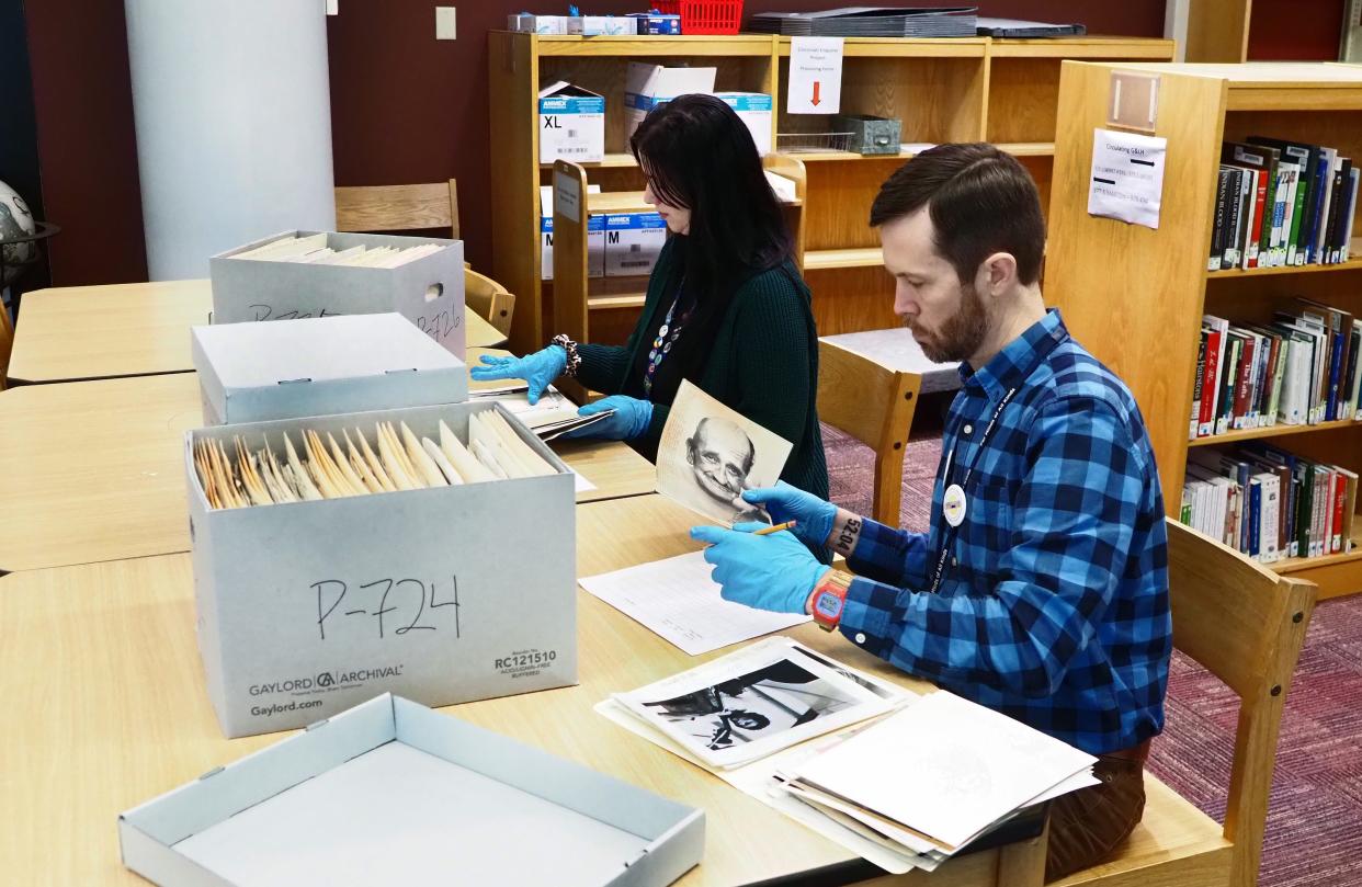 Librarians work with the photo files from The Cincinnati Enquirer Photo Archive. The photos are being digitized and will be available online as part of the public library’s Digital Library.