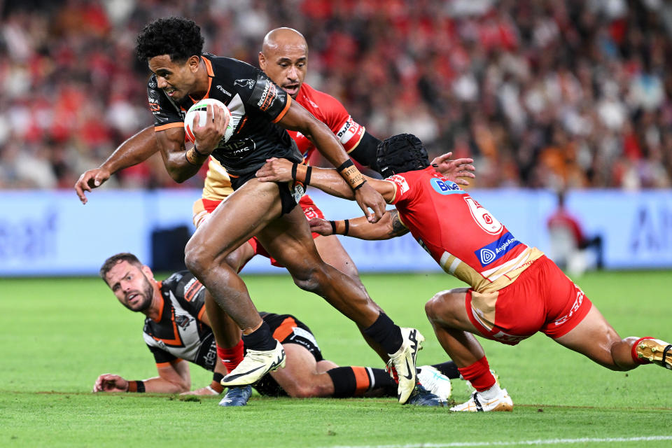 BRISBANE, AUSTRALIA - APRIL 06: Jahream Bula of the Wests Tigers breaks a tackle during the round five NRL match between Dolphins and Wests Tigers at Suncorp Stadium, on April 06, 2024, in Brisbane, Australia. (Photo by Bradley Kanaris/Getty Images)