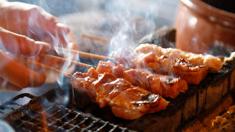 Skewers of chicken being grilled