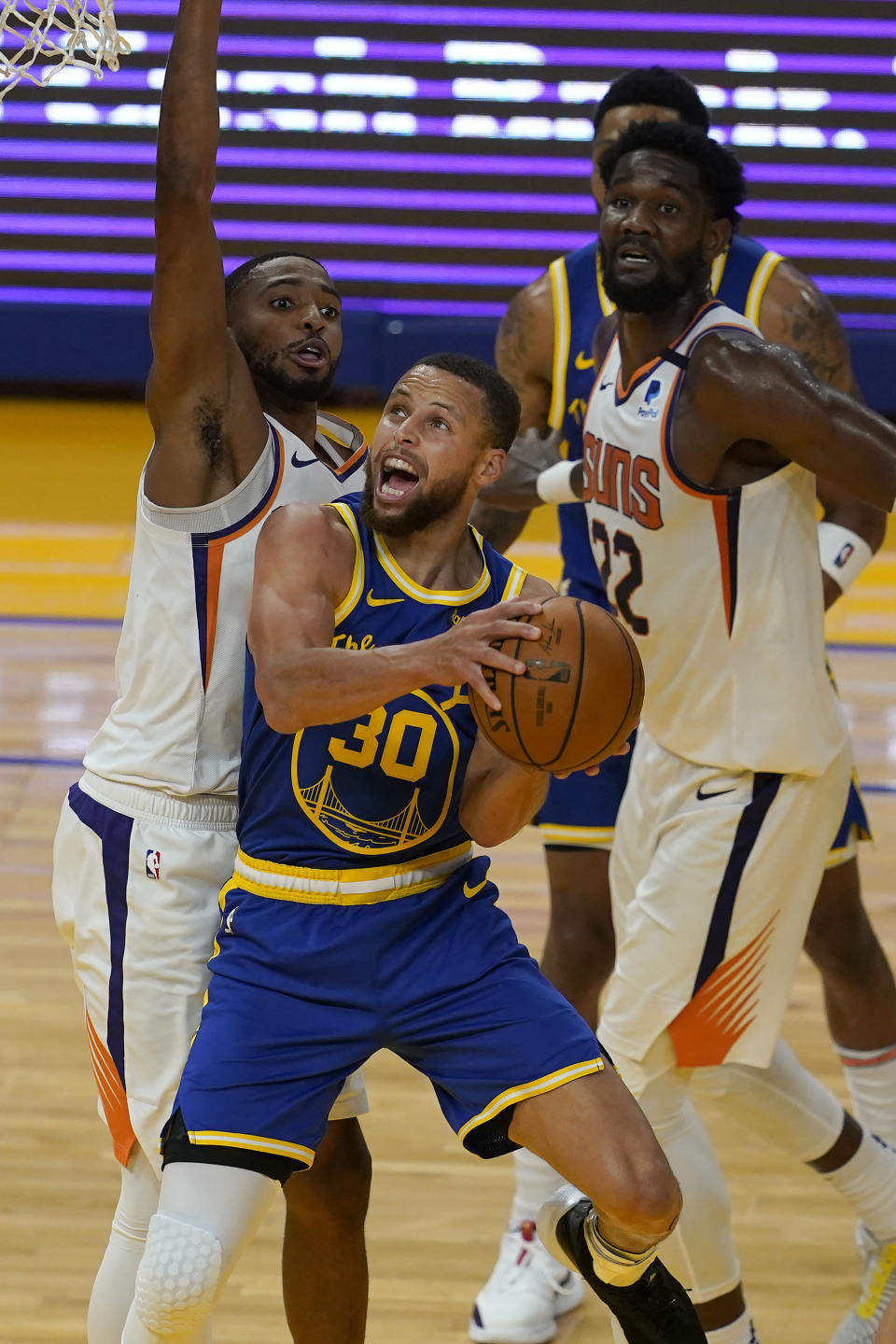 Golden State Warriors guard Stephen Curry (30) shoots in front of Phoenix Suns forward Mikal Bridges, left, and center Deandre Ayton (22) during the second half of an NBA basketball game in San Francisco, Tuesday, May 11, 2021. (AP Photo/Jeff Chiu)